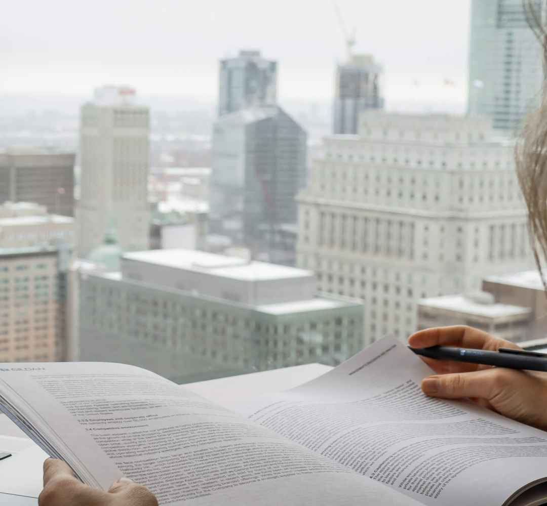 Une femme consulte le rapport annuel de Gildan avec l'horizon de Montréal en arrière-plan.