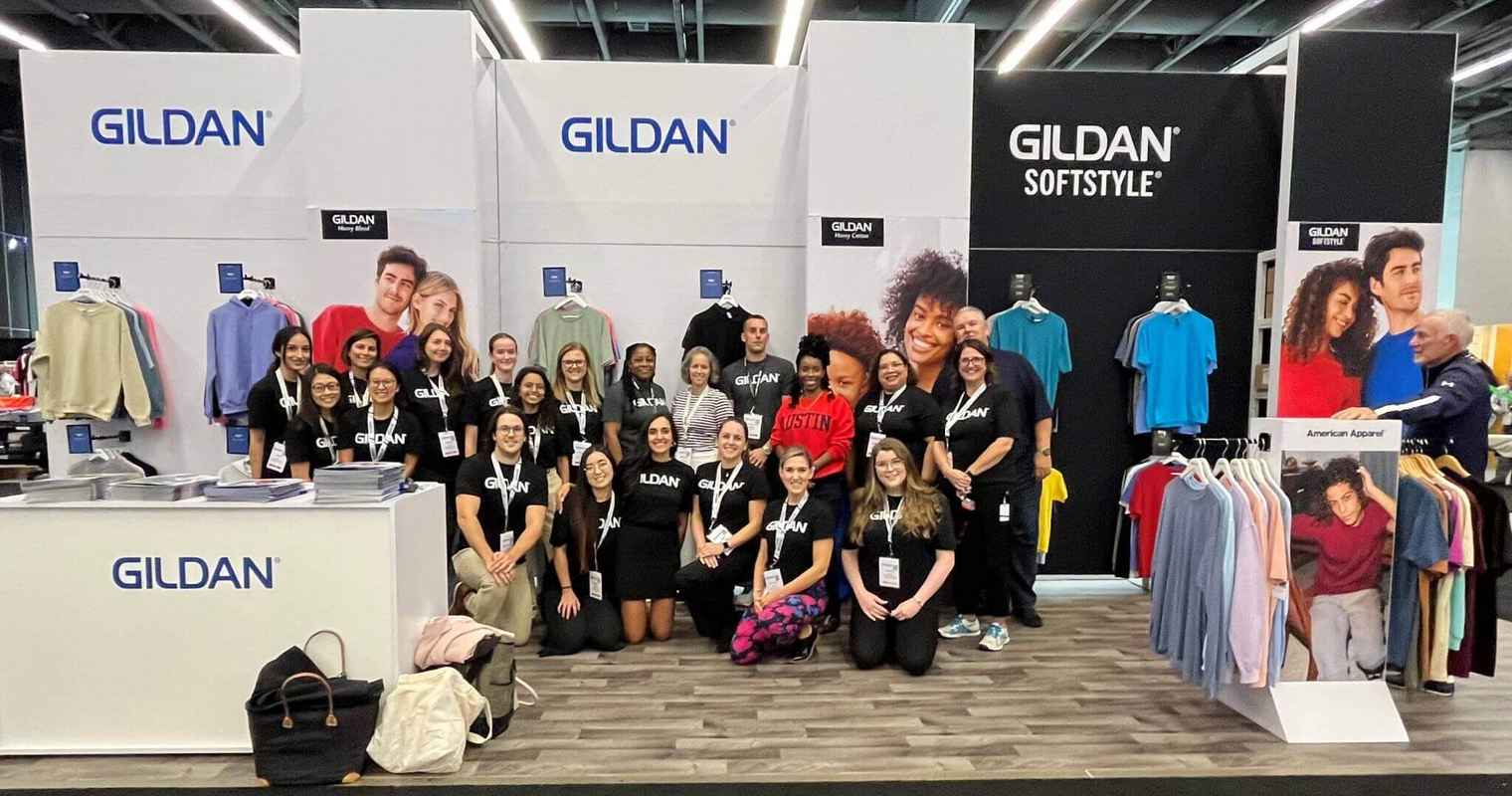 Des employés du siège social de Gildan à Montréal sourient lors d’un salon professionnel.