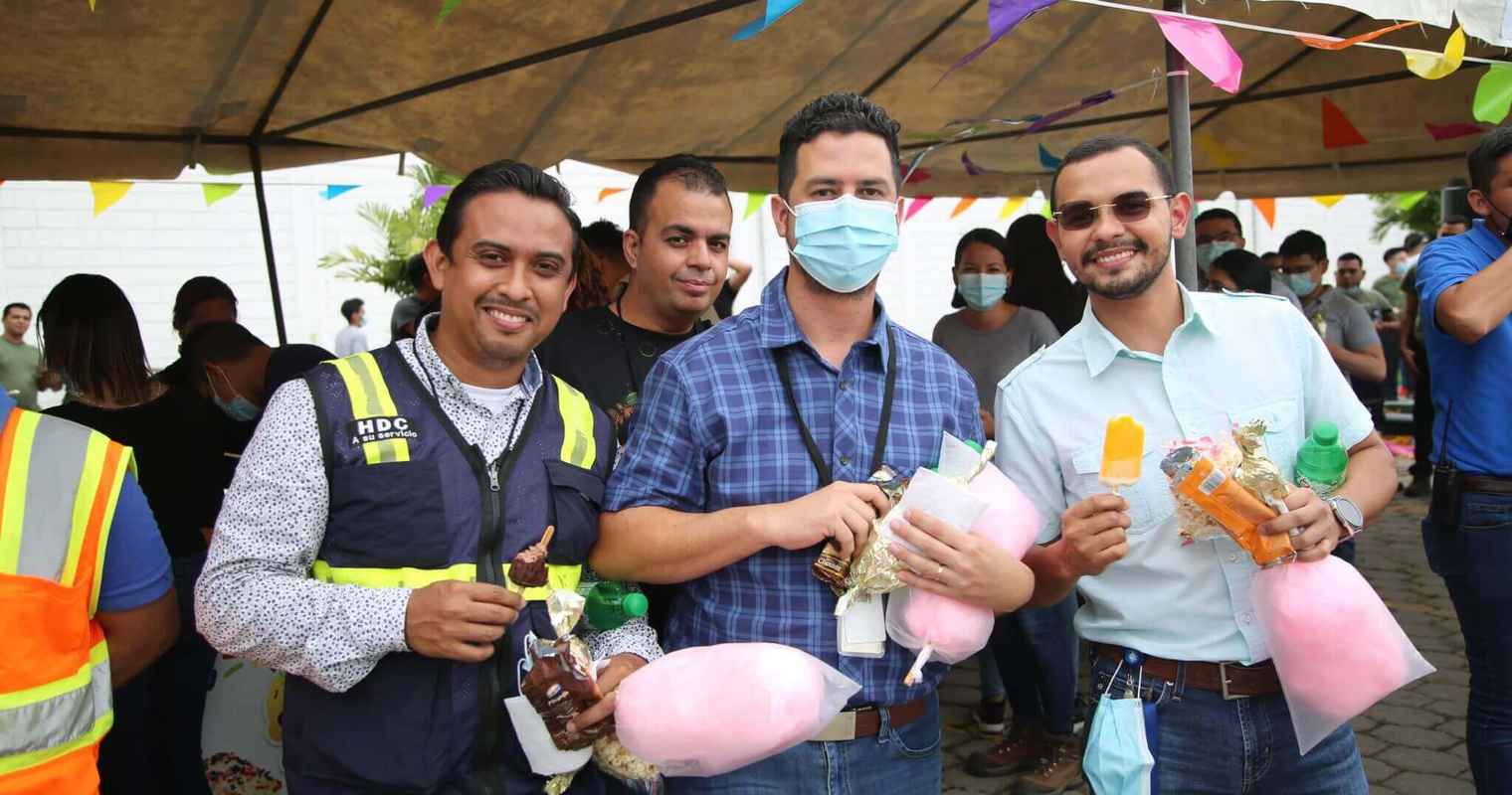 4 employés au Honduras sourient tout en tenant des barbes à papa et la crème glacée à l’extérieur.