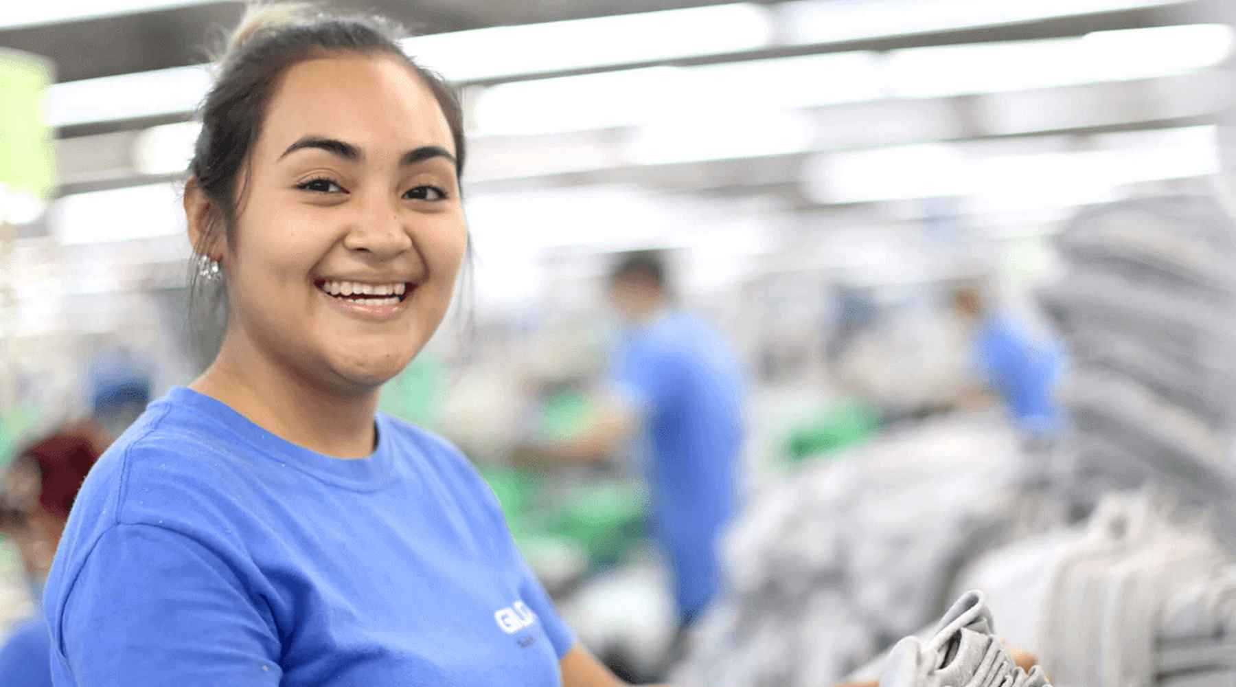 Un employé de la couture gildan sourit à la caméra.