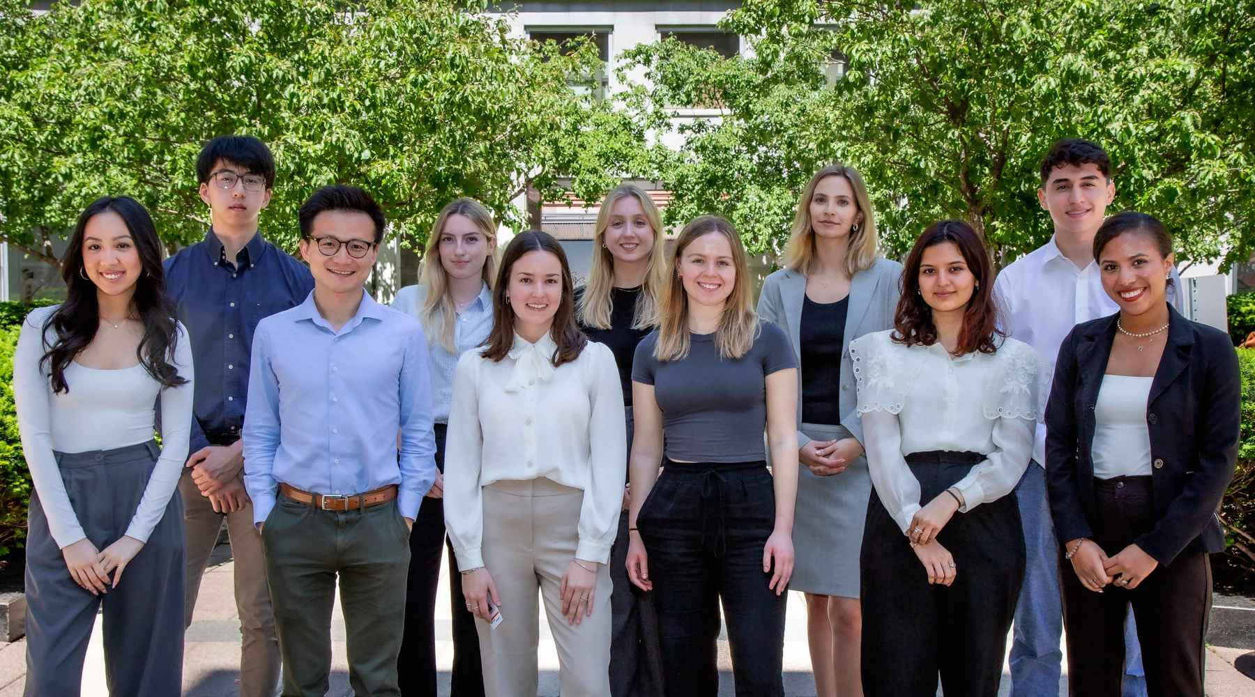 Les stagiaires du siège social de Gildan à Montréal sourient tout en se tenant à l’extérieur.